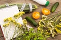 marrow squash, measure tape, blank notepad, bottle of water, flowers, tomatoes and cucumbers on brown wooden table Royalty Free Stock Photo