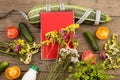 marrow squash, measure tape, blank red notepad, bottle of water, flowers, tomatoes and cucumbers on brown wooden table Royalty Free Stock Photo