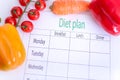 A diet plan on a piece of paper, next to vegetables Royalty Free Stock Photo