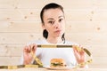 Diet. Portrait woman wants to eat a Burger but stuck skochem mouth, the concept of diet, junk food, willpower in nutrition Royalty Free Stock Photo