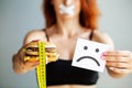 Diet. Portrait woman wants to eat a Burger but stuck skochem mouth, the concept of diet, junk food, willpower in Royalty Free Stock Photo