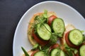 Diet sandwiches with greens, cucumber and tomato on a white plate