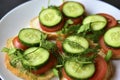 Diet sandwiches with greens, cucumber and tomato on a white plate