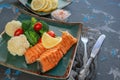 Diet serving of salmon with lemon, broccoli and vegetables. Two pieces of grilled salmon are served on a beautiful plate Royalty Free Stock Photo