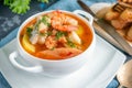 Diet soup of seafood and fish of different varieties in a white soup plate. Close up