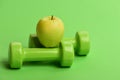 Diet and sport regime concept. Apple fruit near lightweight barbells Royalty Free Stock Photo