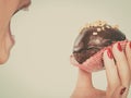 Woman holding chocolate cupcake about to bite Royalty Free Stock Photo