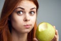 Diet, vitamins A, B, C woman eating an apple, a woman took a bite of an apple and acer portrait background Royalty Free Stock Photo
