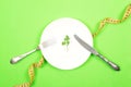 Diet, weigh loss, healthy eating, fitness concept. Small portion of food on big plate. Small green salad leaf on white plate with Royalty Free Stock Photo