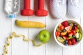 Diet and weight loss for healthy care with  fitness equipment, fresh water and fruit healthy, green apple, banana, cherry on white Royalty Free Stock Photo