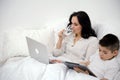 diet weight loss woman drinks water in bed while working on computer son plays tablet proper nutrition Healthy way of Royalty Free Stock Photo