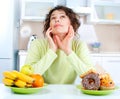 Diet. Woman choosing between Fruits and Sweets Royalty Free Stock Photo