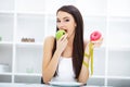 Diet. Woman Measuring Body Weight On Weighing Scale Holding Donut and apple. Sweets Are Unhealthy Junk Food. Dieting, Healthy Eat Royalty Free Stock Photo