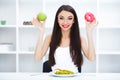 Diet. Woman Measuring Body Weight On Weighing Scale Holding Donut and apple. Sweets Are Unhealthy Junk Food. Dieting, Healthy Eat Royalty Free Stock Photo
