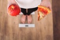 Diet. Woman Measuring Body Weight On Weighing Scale Holding Pizza. Sweets Are Unhealthy Junk Food. Dieting, Healthy Eating, Lifest Royalty Free Stock Photo