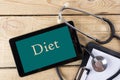 Diet - Workplace of a doctor. Tablet, stethoscope, clipboard on wooden desk background. Top view