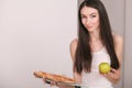 Diet. Young beautiful woman makes a choice between healthy lifestyle and harmful food. The concept of healthy eating and obesity. Royalty Free Stock Photo