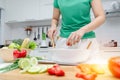 Diet. young pretty woman in green shirt standing and preparing the vegetables salad in bowl for good healthy in modern kitchen Royalty Free Stock Photo