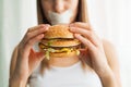 Diet. Young woman with duct tape over her mouth, preventing her to eat junk food. Healthy eating concept Royalty Free Stock Photo