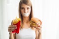 Diet. Young woman with duct tape over her mouth, preventing her to eat junk food. Healthy eating concept Royalty Free Stock Photo