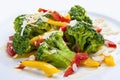 Dietary broccoli with vegetables and peanuts. On a white plate