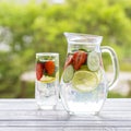 Dietary detox drink with lemon juice, red strawberry, cucumber and mint leaves in clear water with ice.