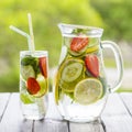 Dietary detox drink with lemon juice, red strawberry, cucumber and mint leaves in clear water with ice. Royalty Free Stock Photo