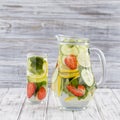 Dietary detox drink with lemon juice, red strawberry, cucumber and mint leaves in clear water with ice. Royalty Free Stock Photo