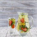 Dietary detox drink with lemon juice, red strawberry, cucumber and mint leaves in clear water with ice. Royalty Free Stock Photo