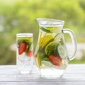 Dietary detox drink with lemon juice, red strawberry, cucumber and mint leaves in clear water with ice. Royalty Free Stock Photo