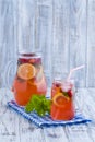 Dietary detox drink with lemon juice, red strawberry and mint leaves in clear water with ice Royalty Free Stock Photo