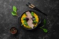 Dietary nutrition. Boiled veal with corn and spinach in a black bowl.