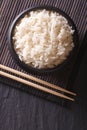 Dietary rice in a black bowl close-up vertical top view