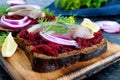 Dietary sandwiches with beets, slices of salted herring and red onion on rye bread on a black background Royalty Free Stock Photo
