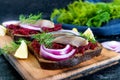 Dietary sandwiches with beets, slices of salted herring and red onion on rye bread on a black background Royalty Free Stock Photo