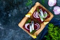 Dietary sandwiches with beets, slices of salted herring and red onion on rye bread on a black background. Royalty Free Stock Photo