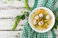 Dietary soup with chicken meatballs and green peas in a white bowl on a wooden background. Royalty Free Stock Photo