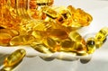 Omega 3 fish oil pills. Copy space background. Yellow shining capsules pouring out of a bottle. Royalty Free Stock Photo