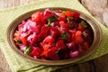 Dietary tasty Moroccan salad from boiled beet with onions, tomatoes and herbs with olive oil close-up on a plate. horizontal