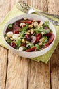 Dietary vitamin salad of arugula, baked beets, cherries, mozzarella, hazelnuts close-up in a bowl. Vertical Royalty Free Stock Photo