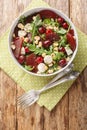 Dietary vitamin salad of arugula, baked beets, cherries, mozzarella, hazelnuts close-up in a bowl. Vertical top view Royalty Free Stock Photo