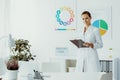 Dietician with notes and standing in her office