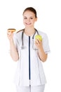 Dietician holding sweet doughnut and fresh healthy green apple.