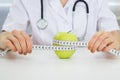 Dietician measuring green apple