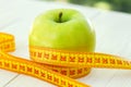 Dieting concept. Green apple with measuring tape. Green apples measured the meter, sports apple