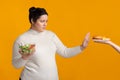 Overweight girl refusing fast food, holding bowl with fresh vegetable salad Royalty Free Stock Photo