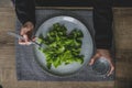 Top view of woman hands and big grey plate with green leaves of salad. Royalty Free Stock Photo