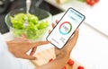 Dieting Concept. Woman eating salad and counting calories with app on smartphone Royalty Free Stock Photo