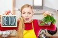 Woman holding detox sign and shopping basket with