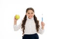 Dieting and health. Development of children. Little child smiling with tooth brush and green apple. Happy girl isolated